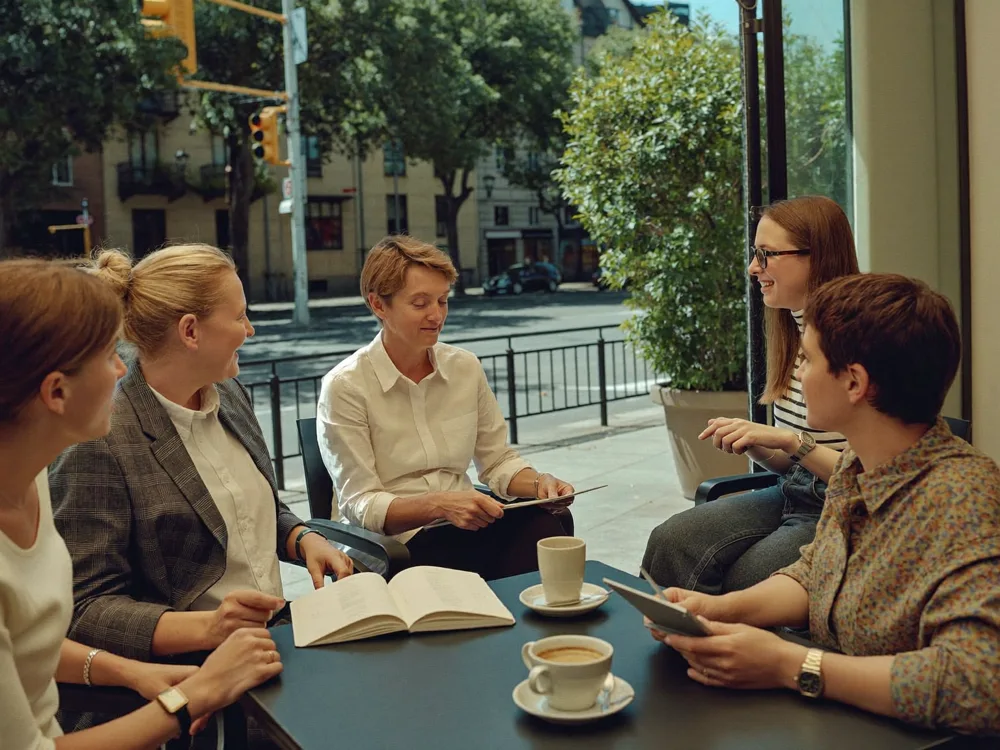 Colegas conversando y compartiendo ideas en un café de barrio
